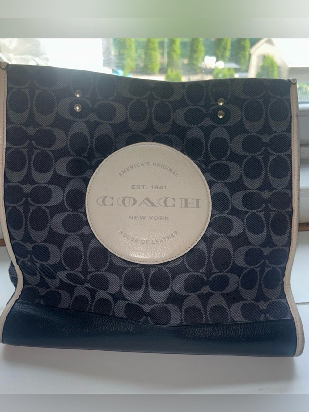 Coach Dempsey Tote  signature denim and a circular leather logo patch.